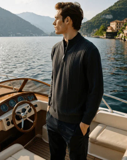 Man in dark sweater standing on luxury boat, scenic lake and mountains background