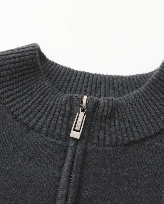 Close-up of charcoal knit zip-up sweater collar with ribbed neckline