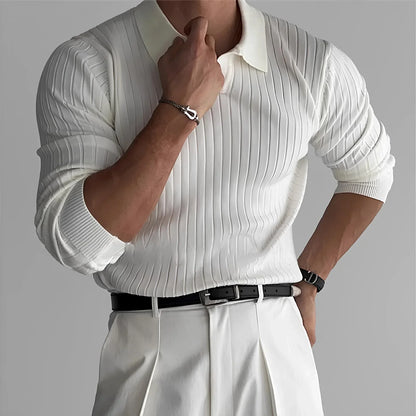 Man wearing white ribbed knit sweater, white pleated trousers, and black belt